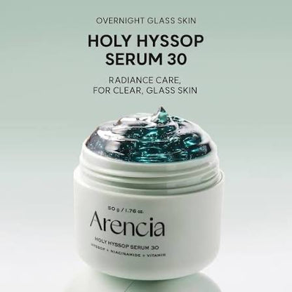 A white jar of Arencia Holy Hyssop Serum 30 with a clear lid showing blue-green gel inside, set against a light green gradient background with product text above.